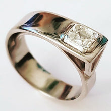 Load image into Gallery viewer, A platinum band ring with a central square-cut diamond, reflective metallic surface.