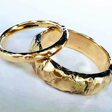 Load image into Gallery viewer, Two chunky, textured wedding rings made from recycled 9ct yellow gold, displayed on a white surface.