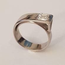 Load image into Gallery viewer, A platinum band ring with a central square-cut diamond, reflective metallic surface.