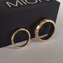 Load image into Gallery viewer, Two chunky, textured wedding rings made from recycled 9ct yellow gold, displayed on a white surface.