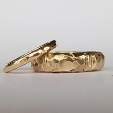 Load image into Gallery viewer, Two chunky, textured wedding rings made from recycled 9ct yellow gold, displayed on a white surface.