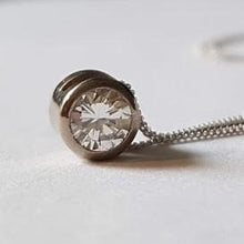 Load image into Gallery viewer, A diamond solitaire pendant with a silver chain attached, set on a white background.