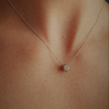 Load image into Gallery viewer, A diamond solitaire pendant with a silver chain attached worn by model close up