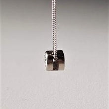 Load image into Gallery viewer, Side view of diamond solitaire pendant with a silver chain attached, set on a white background.