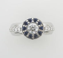 Load image into Gallery viewer, 18ct white gold ring, featuring a striking star-shaped setting surrounded by a halo of sapphire petals, with diamonds extending along the shoulders.